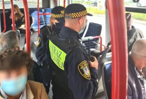 policjanci i straż miejska kontrolują osoby podróżujące autobusem miejskim