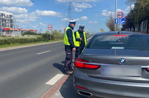 2 policjantów stoi przy kontrolowanym samochodzie marki BMW