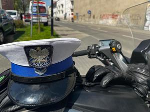 na policyjnym motocyklu leżą rękawiczki skórzane i biała czapka policyjna