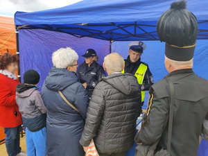policjanci rozmawiają ze zgromadzonymi osobami, które ustawiły się przy namiocie policyjnym