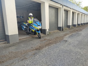 Policjant na motocyklu wyjeżdża z garażu