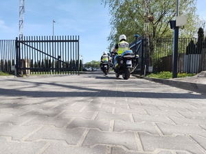 Policjanci na motocyklach wyjeżdżają z bramy