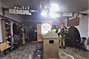Funkcjonariusze straży pożarnej w pomieszczeniu, które się paliło.