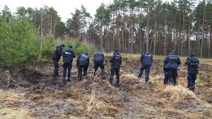 Umundurowani policjanci przeczesujący las