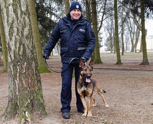 zdjęcie przedstawia policjanta z psem słuzbowym