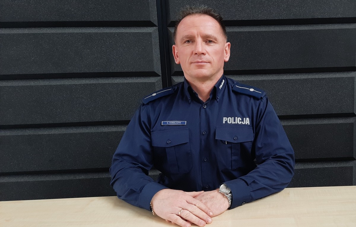 Umundurowany policjant siedzi przy biurku