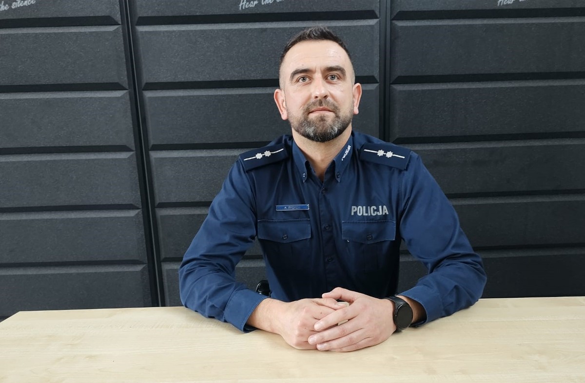 Policjant w mundurze siedzi za biurkiem
