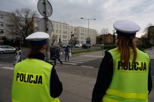 Policjantki przyglądają się ruchowi w obrębie przejścia dla pieszych.