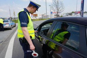 Policjant sprawdza trzeźwość kierującego.