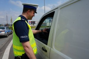 Policjant sprawdza trzeźwość kierującego.