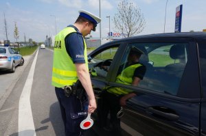 Policjant sprawdza trzeźwość kierującego.