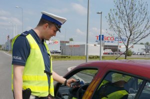 Policjant sprawdza trzeźwość kierującego.