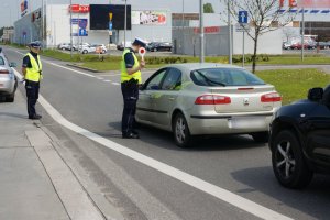 Policjant sprawdza trzeźwość kierującego.