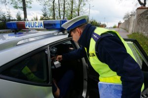 Policjant sprawdza stan trzeźwości kierującego.