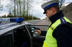 Policjant sprawdza stan trzeźwości kierującego.