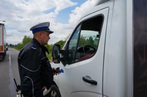 Policjant sprawdza stan trzeźwości kierującego.