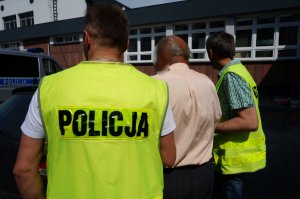 Policjanci prowadzą zatrzymanego.