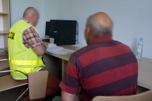 Policjant przesłuchuje zatrzymanego.