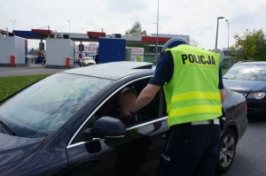 Policjant sprawdza stan trzeźwości kierującego.