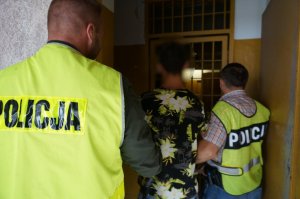 Policjanci prowadza zatrzymanego.