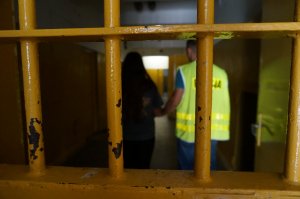 Policjant prowadzi zatrzymaną.