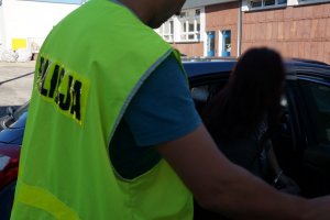 Policjant prowadzi zatrzymaną.