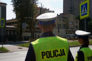 Policjanci lustrują drogę przy szkołę.