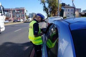 Policjantka podczas kontroli drogowej.