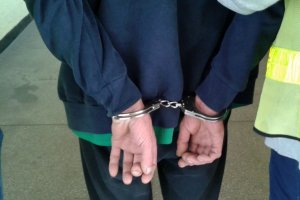Policjanci prowadzą zatrzymanego.