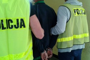 Policjanci prowadzą zatrzymanego.