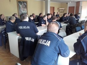 Policjanci siedzą na sali wykłądowej