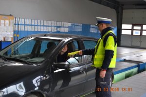 Policjant przekazuje odblaski