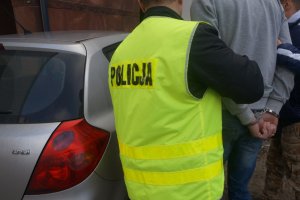 Policjanci prowadzą zatrzymanego.
