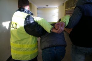 Policjanci prowadzą zatrzymanego.