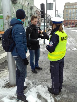 Piesi otrzymują od policjantki odblaski