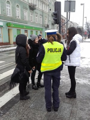 Piesi otrzymują od policjantki odblaski
