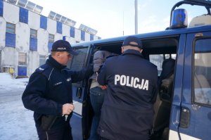 Policjanci prowadzą zatrzymanego.