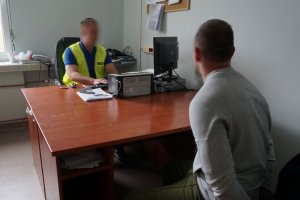 Policjant przesłuchuje zatrzymanego.