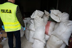 Policjant przy zabezpieczonym tytoniu.