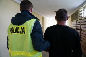 Policjanci prowadzą zatrzymanego.