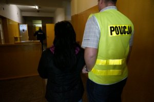 Policjant prowadzi zatrzymaną.