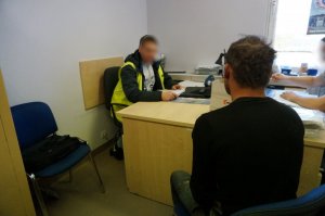 Policjant przesłuchuje zatrzymanego.