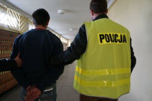 Policjanci prowadzą zatrzymanego.