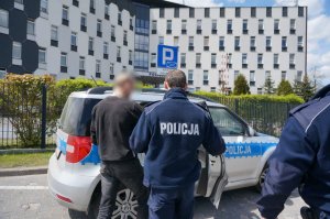 Policjanci prowadzą zatrzymanego.