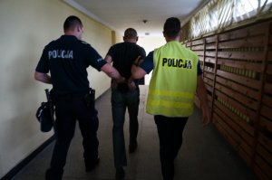 Policjanci prowadzą zatrzymanego.