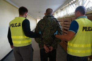 Policjanci prowadzą zatrzymanego.
