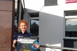 Policjantka z plakatem o Międzynarodowym Dniu Mediacji.