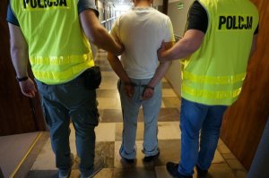 Policjanci prowadzą zatrzymanego.