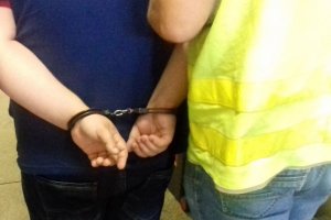 Policjanci prowadzą zatrzymanych.