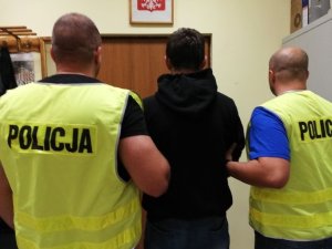 Policjanci prowadzą zatrzymanego